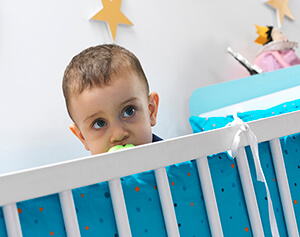 mavi renkli beşikte oturan emzikli erkek bebek